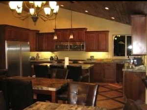 Kitchen featuring stainless steel fridge, a notable chandelier, tile patterned floors, and lofted ceiling