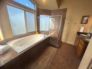 Bathroom with shower with separate bathtub, tile patterned floors, and double sink vanity