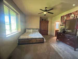 Carpeted bedroom featuring ceiling fan