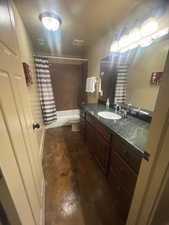 Full bathroom with shower / tub combo with curtain, vanity, toilet, and concrete floors