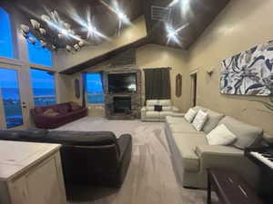 Cinema room featuring a stone fireplace, carpet floors, and a high ceiling