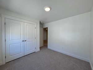 Unfurnished bedroom with a closet and carpet floors