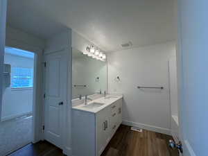 Bathroom featuring hardwood / wood-style flooring, double sink vanity, and water closet