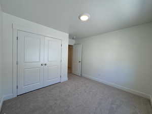 Bedroom with light carpet and a closet