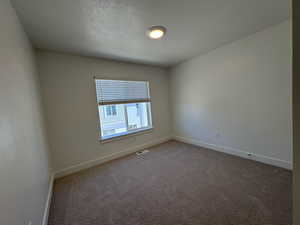 Carpeted Bedroom 2 with large window and blinds