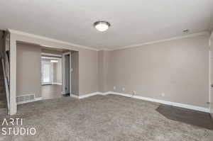 Carpeted empty room featuring ornamental molding