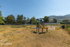 View of jungle gym featuring a yard and a mountain view