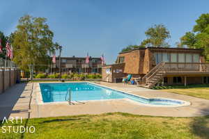 View of pool featuring a patio area, a yard, and a wooden deck