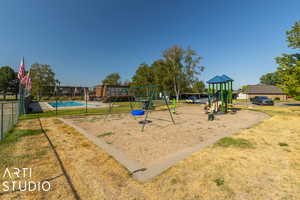 View of playground with a yard and a fenced in pool