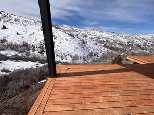 Snow covered deck featuring a mountain view