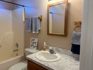 Full bathroom with vanity, tub / shower combination, and toilet