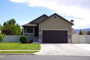 View of front of property featuring a garage and a front lawn