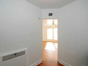 Hallway with hardwood / wood-style floors