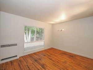 Spare room featuring hardwood / wood-style floors and radiator