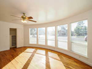 Unfurnished sunroom with plenty of natural light and ceiling fan