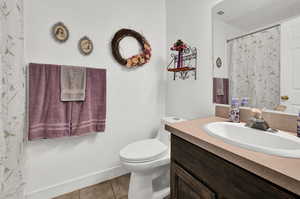 Bathroom with vanity, toilet, and tile patterned floors