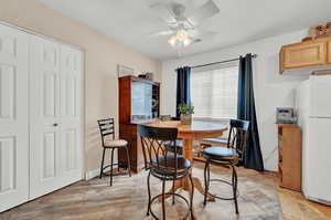 Dining area with ceiling fan and light hardwood / wood-style floors