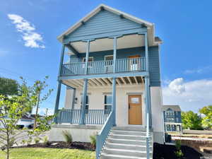 View of front of home with covered porch and a balcony