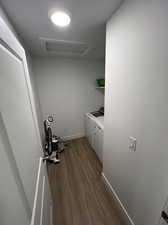 Washroom with hardwood / wood-style flooring and washing machine and clothes dryer