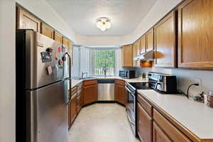 Kitchen featuring sink, stainless steel appliances, and a textured ceiling