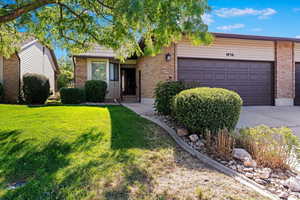 Ranch-style home with a front lawn and a garage