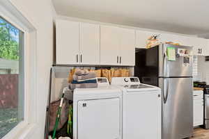 Clothes washing area featuring light hardwood / wood-style flooring and washer and dryer