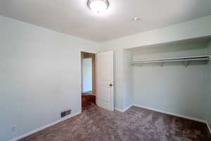 Unfurnished 1 of 2 upstairs bedroom featuring a closet and carpet