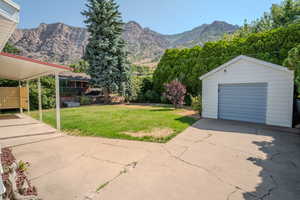 View of back yard featuring a second garage, an outbuilding, and a mountain view