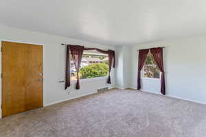 Carpeted spare room with a wealth of natural light