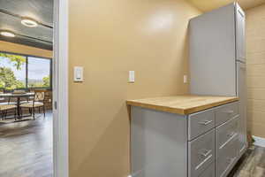 Interior space featuring gray cabinets, dark hardwood / wood-style floors, and wooden counters