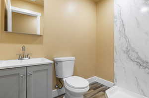 Bathroom featuring vanity, hardwood / wood-style flooring, and toilet