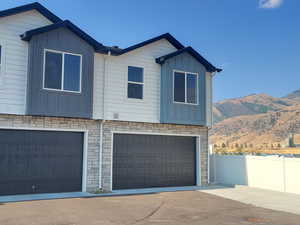 View of front of home with a garage and a mountain view