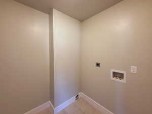 Washroom featuring electric dryer hookup, hookup for a washing machine, and light tile patterned floors