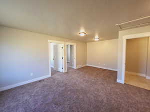 Unfurnished room featuring light carpet and a textured ceiling