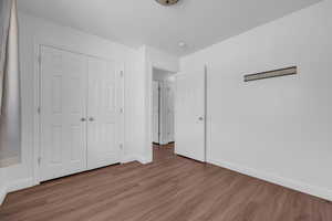 Unfurnished bedroom featuring a closet and hardwood / wood-style floors