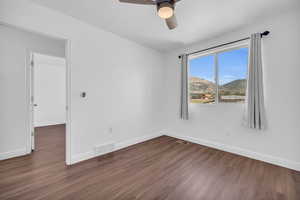 Spare room with dark hardwood / wood-style floors and ceiling fan