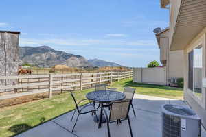 View of patio featuring central AC, a mountain view, and a rural view