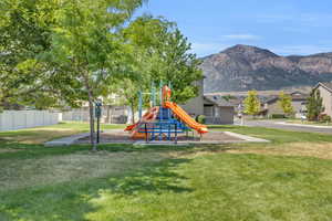 View of play area featuring a mountain view and a lawn