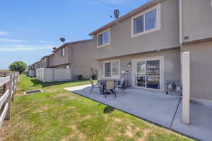 Back of house featuring a patio area and a lawn