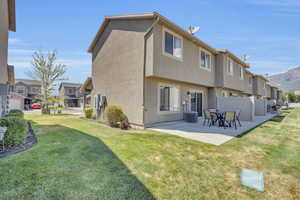 Back of house with a patio, central AC, and a yard