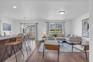 Living room featuring sink, a chandelier, and light hardwood / wood-style flooring