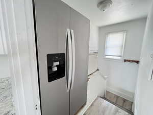 Kitchen featuring stainless steel fridge and light hardwood / wood-style floors