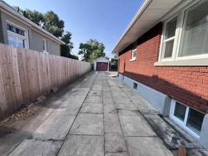 View of side of home featuring a garage, an outbuilding, and a patio area