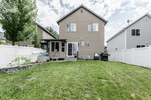 Rear view of property featuring a patio area and a yard