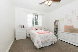 Carpeted bedroom featuring ceiling fan