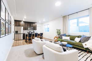 Living room with a healthy amount of sunlight and light hardwood / wood-style floors