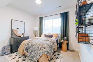 Bedroom featuring light carpet