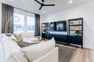 Living room with ceiling fan and light hardwood / wood-style flooring