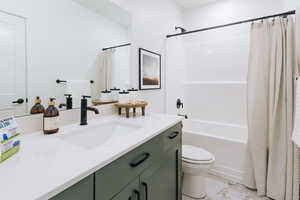 Full bathroom with shower / tub combo, tile patterned flooring, toilet, and vanity