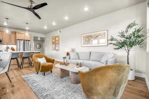 Living room with light wood-type flooring and ceiling fan